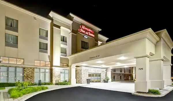 Exterior view of Hampton Inn & Suites Guelph at night, with illuminated entrance and well-maintained landscaping.