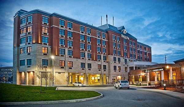 Exterior view of Delta Hotels by Marriott Guelph Conference Centre at dusk, with warm lighting and a welcoming entrance.