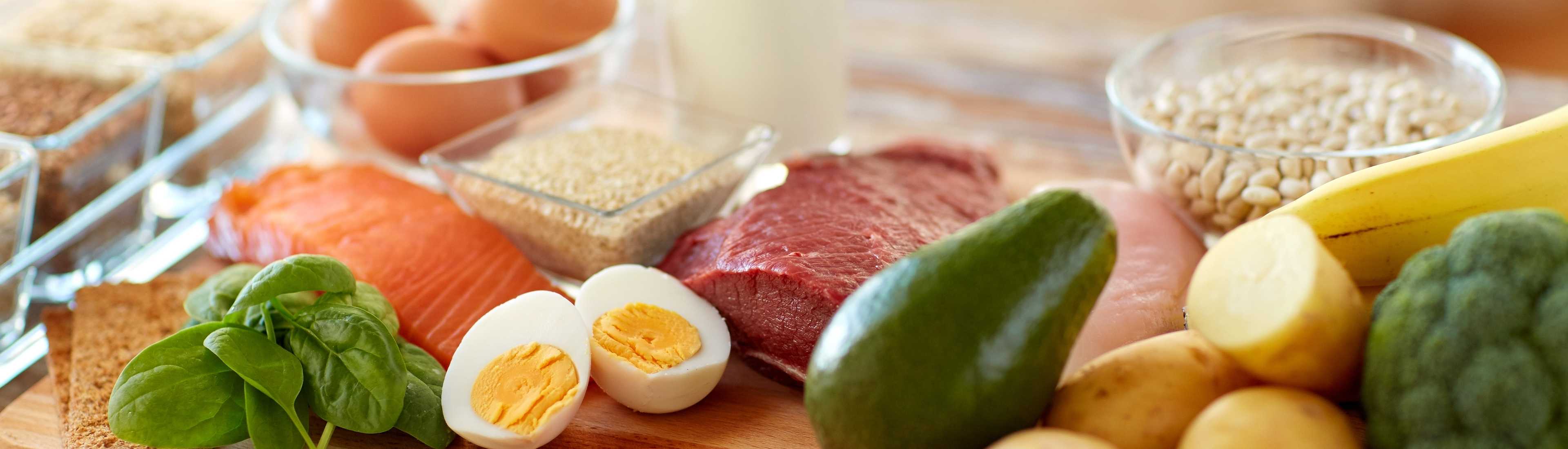Variety of protein-rich foods including eggs, meat, fish, avocado, spinach, and dairy, showcasing the importance of protein in building resilience as we age. Key ingredients for a healthy diet in older adults.